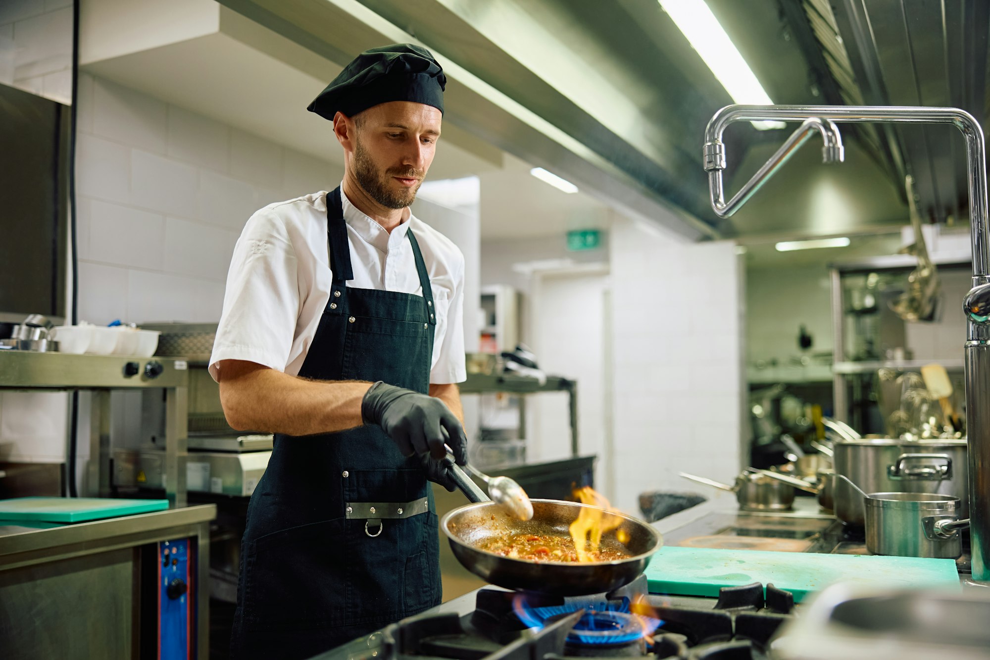 Male chef cooking while working in the kitchen.